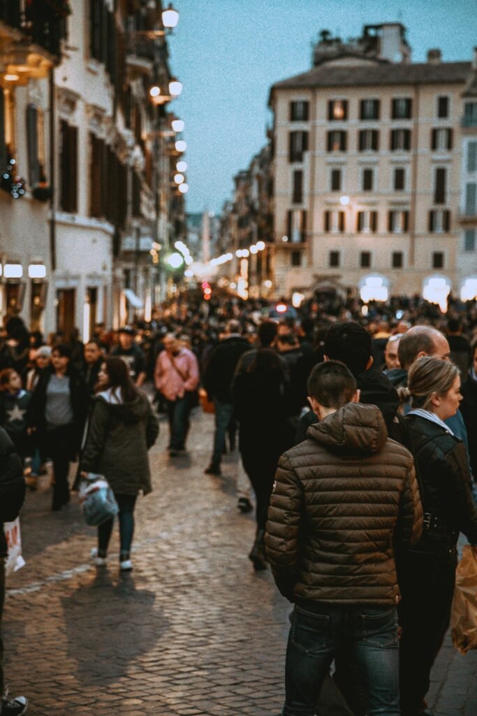 pexels-photo-2064826-2064826 A vibrant street filled with people in the evening, showcasing urban life and city architecture.